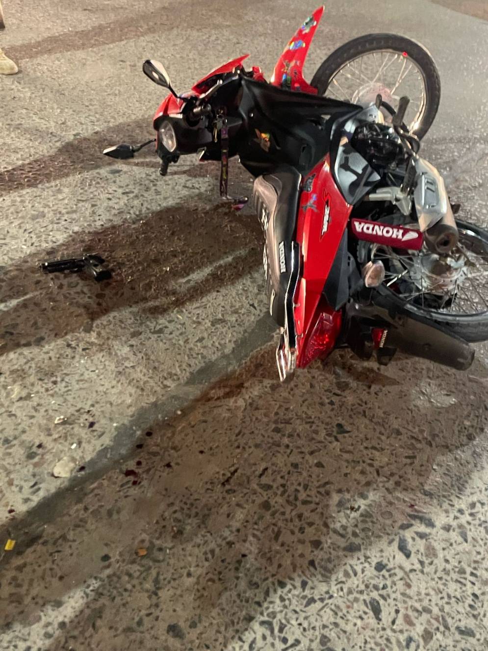 La moto y la pistola de utiler&iacute;a, en el asfalto de Avenida Libertad y 25 de Mayo. 