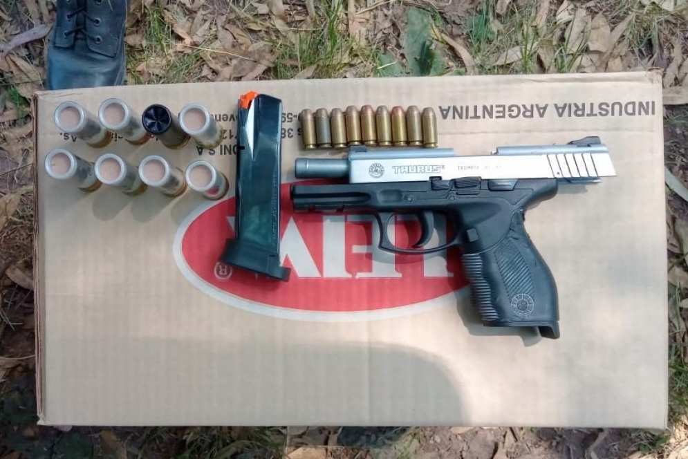 La pistola Taurus junto a sus municiones y a los 8 cartuchos de la escopeta.