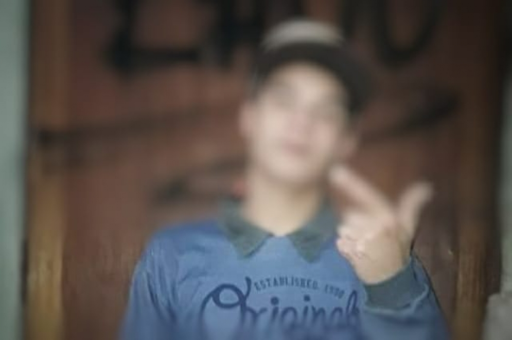 Uno de los menores haciendo el s&iacute;mbolo de la pistola en las redes sociales.