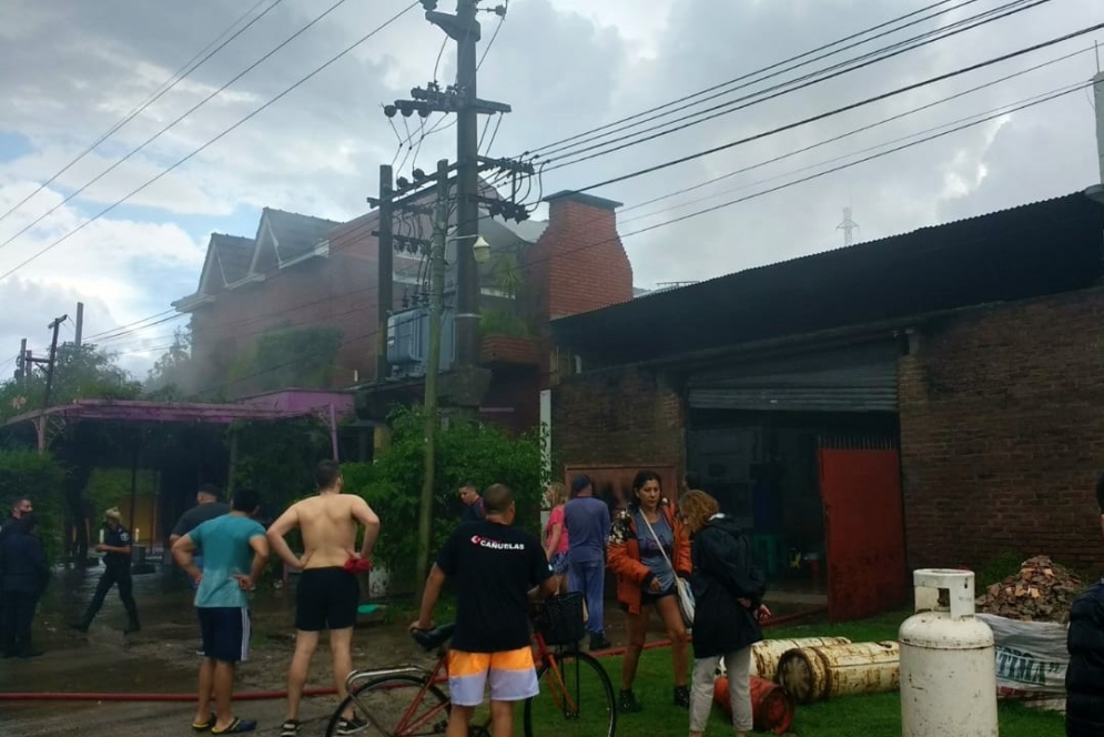 La gente observando el accionar de los bomberos a metros de las garrafas de gas que ya estaban a salvo en la vereda. (FOTO: Germ&aacute;n Senas).